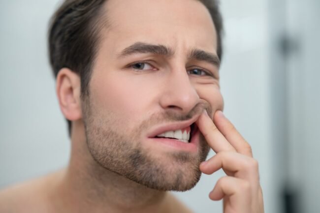 Man checking his teeth and looking disturbed Man checking his teeth and looking disturbed